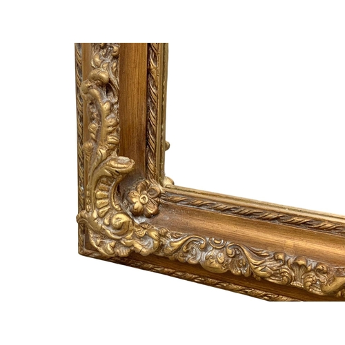 894 - A very large heavily gilt framed mirror. 100 x 214cm