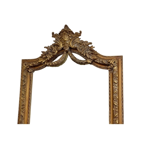 894 - A very large heavily gilt framed mirror. 100 x 214cm