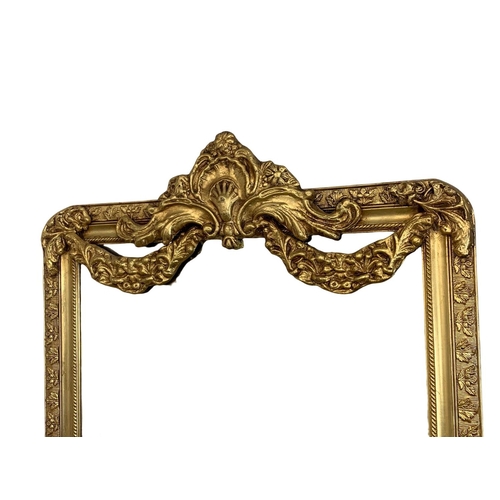 895 - A very large heavily gilt framed mirror. 90.5 x 212cm.