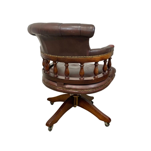 910 - A vintage deep button ox-blood leather swivel captains desks chair.