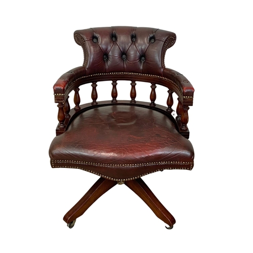 910 - A vintage deep button ox-blood leather swivel captains desks chair.