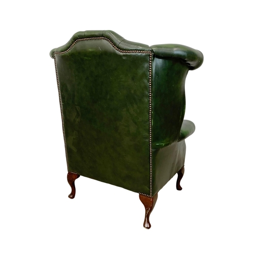 918 - A deep button green leather wingback armchair