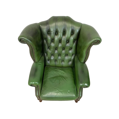 918 - A deep button green leather wingback armchair