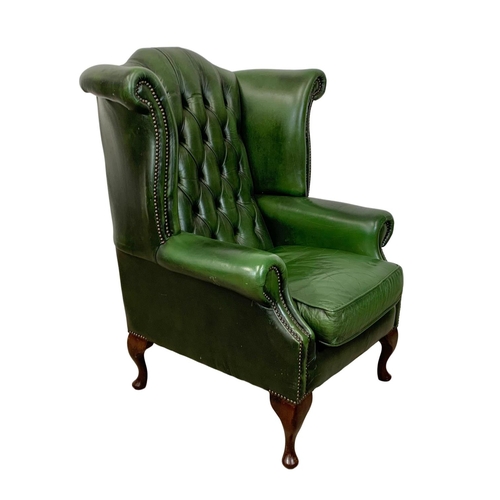 918 - A deep button green leather wingback armchair