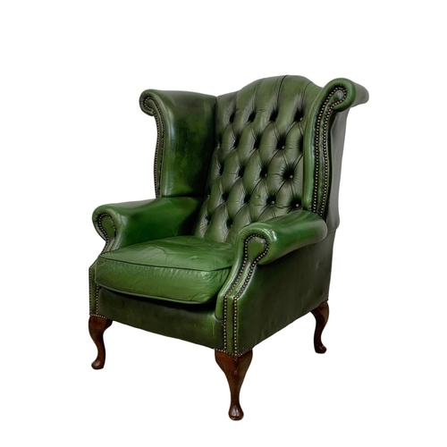 918 - A deep button green leather wingback armchair