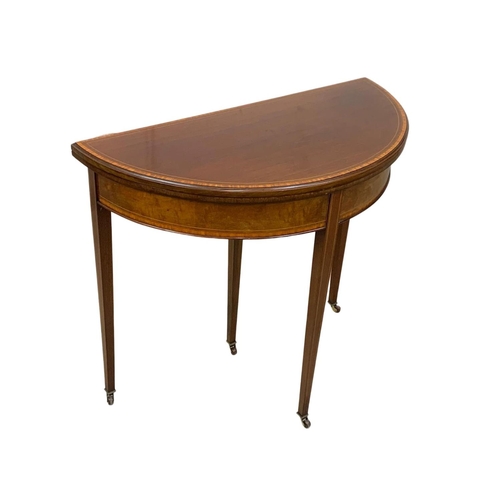 963a - An Edwardian Sheraton revival inlaid mahogany turnover games table. 84 x 41.5 x 76cm.