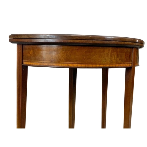 963a - An Edwardian Sheraton revival inlaid mahogany turnover games table. 84 x 41.5 x 76cm.