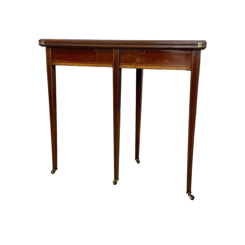 963a - An Edwardian Sheraton revival inlaid mahogany turnover games table. 84 x 41.5 x 76cm.