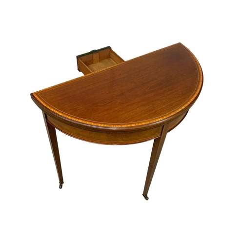 963a - An Edwardian Sheraton revival inlaid mahogany turnover games table. 84 x 41.5 x 76cm.