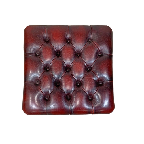 984 - A deep button ox-blood leather footstool. 52 x 30cm