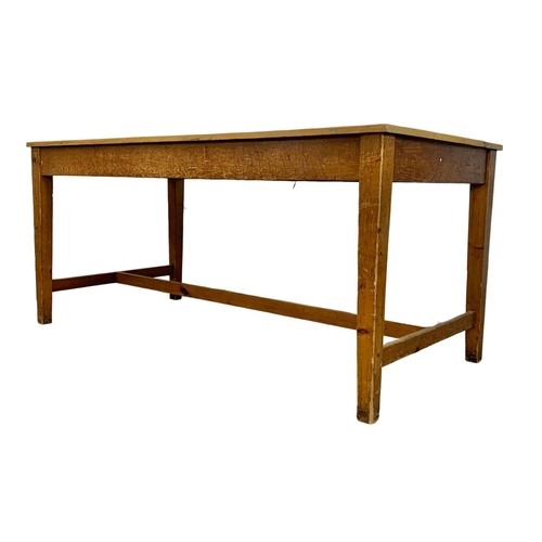 986 - A large late 19th century pine farmhouse table with stretcher support and original refinished top. C... 