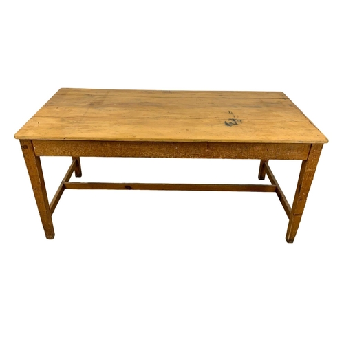 986 - A large late 19th century pine farmhouse table with stretcher support and original refinished top. C... 