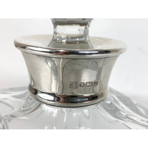 462 - A large heavy crystal decanter with a London Silver top. 9.5 x 26cm