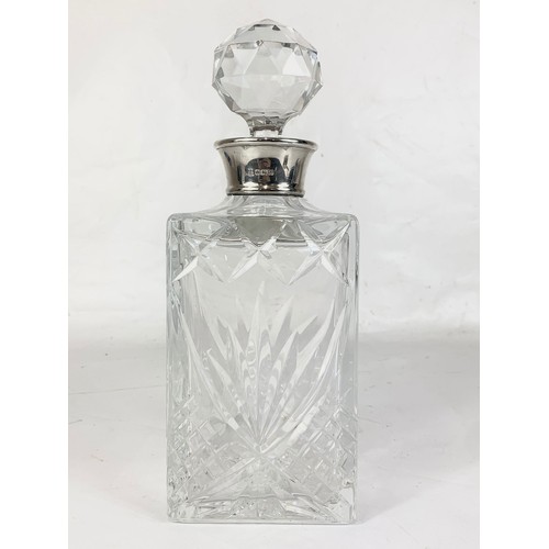 462 - A large heavy crystal decanter with a London Silver top. 9.5 x 26cm