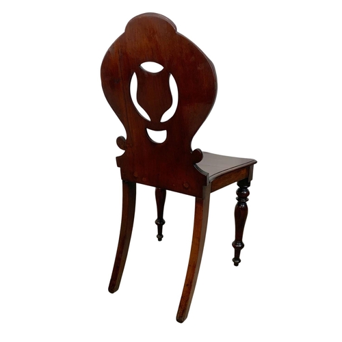 872 - A pair Victorian carved mahogany hall chairs.