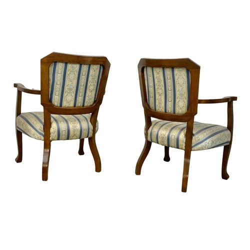 857a - A pair of 1930's armchairs in a beech frame with simulated walnut back rest.