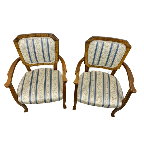 857a - A pair of 1930's armchairs in a beech frame with simulated walnut back rest.