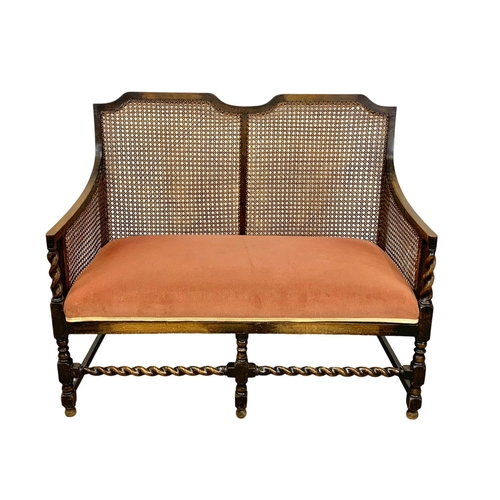 1033 - A 1920’s oak and bergere 2 seater sofa 114 x 97 x 61cm.