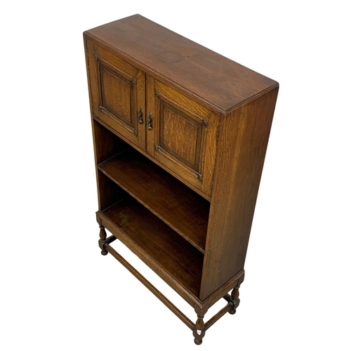 1045 - A 1930’s oak bookcase with 2 door cupboard. 61 x 22 x 107cm