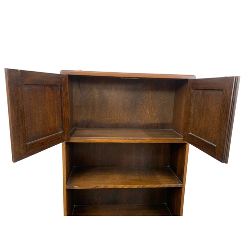 1045 - A 1930’s oak bookcase with 2 door cupboard. 61 x 22 x 107cm