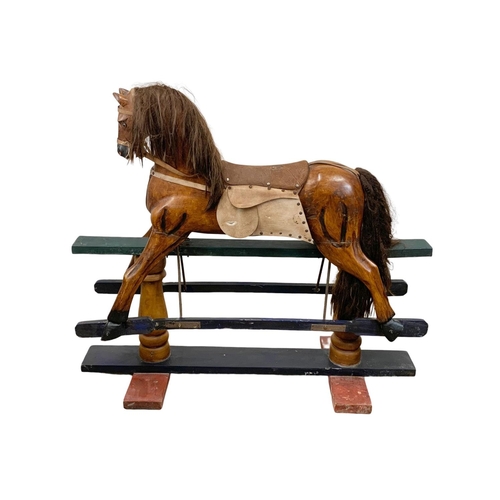 1055 - A large wooden rocking horse. 134 x 117cm.