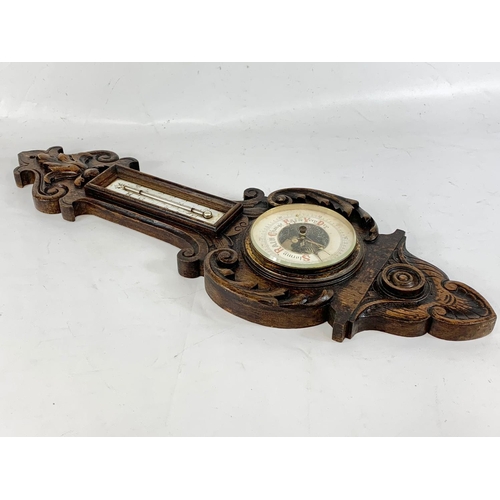 126 - A late Victorian carved oak barometer 72cm.