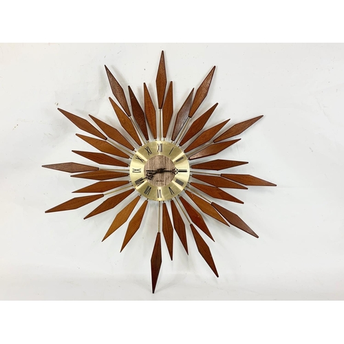 13 - A Mid Century teak sunburst wall clock by Seth Thomas. 80.5cm.