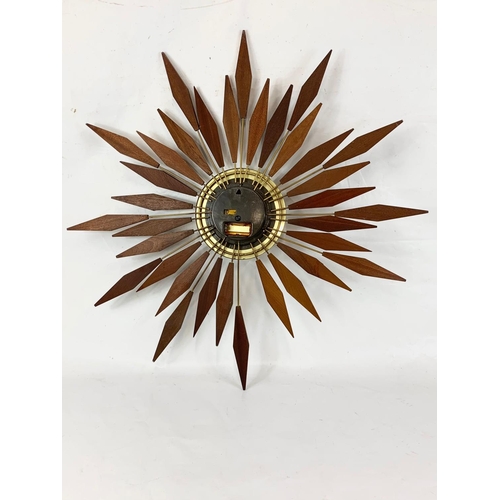 13 - A Mid Century teak sunburst wall clock by Seth Thomas. 80.5cm.