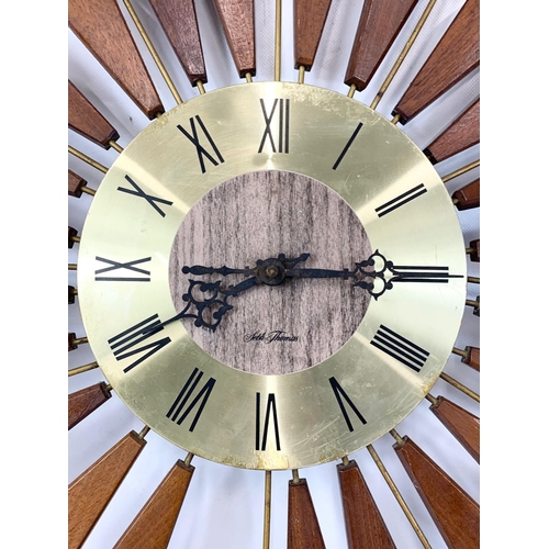 13 - A Mid Century teak sunburst wall clock by Seth Thomas. 80.5cm.