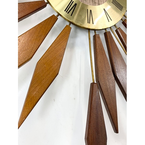 13 - A Mid Century teak sunburst wall clock by Seth Thomas. 80.5cm.