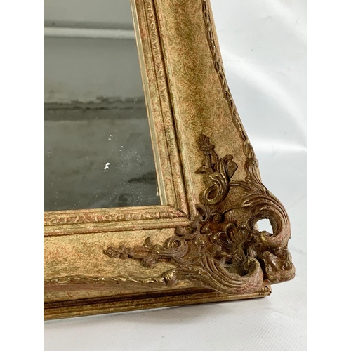 184 - An ornate gilt framed mirror. 87.5 x 62cm