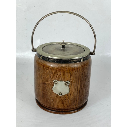 236 - An Edwardian oak biscuit barrel and a Victorian brass trivet stand. 27 x 17 x 15cm