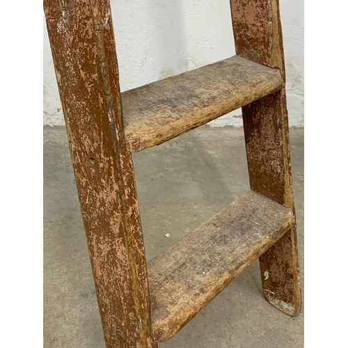 245 - A large early 20th century pine step ladder with original paint. 191.5cm folded.