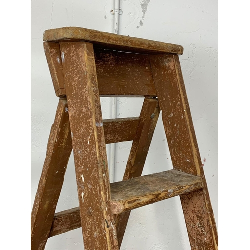 245 - A large early 20th century pine step ladder with original paint. 191.5cm folded.