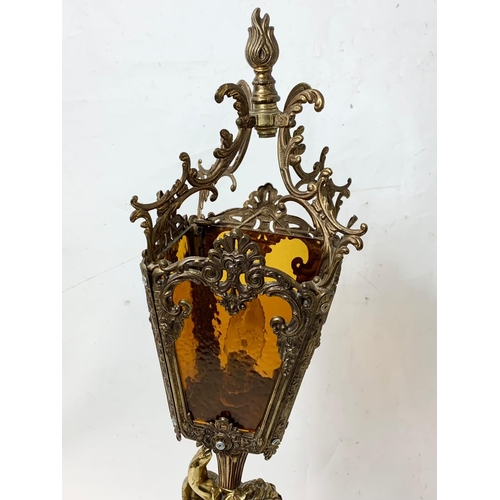 283 - A large ornate brass table lamp with amber glass panels. 73cm