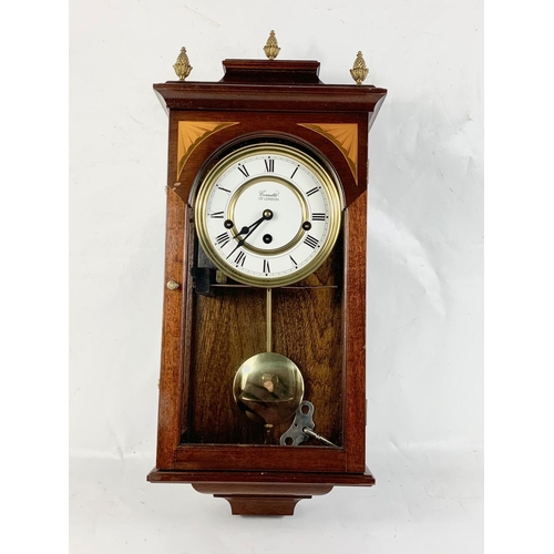 3 - An inlaid mahogany wall clock. Comitti of London. 52cm