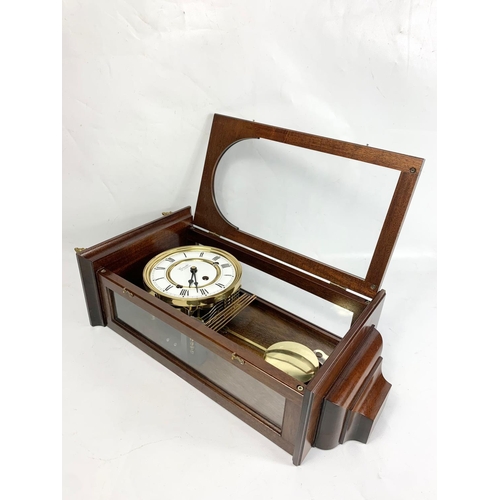 3 - An inlaid mahogany wall clock. Comitti of London. 52cm