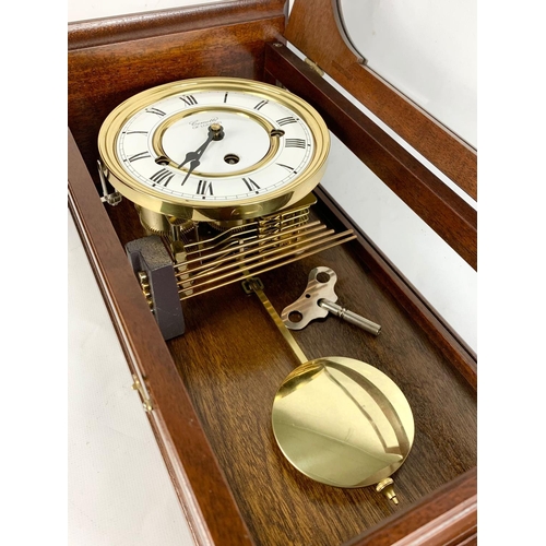 3 - An inlaid mahogany wall clock. Comitti of London. 52cm