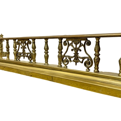 308 - A vintage heavy brass fender. Interior 123 x 30cm. Exterior 137 x 37.5cm