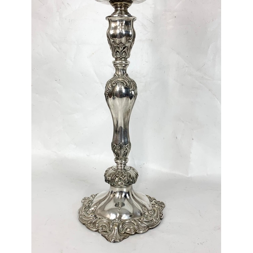 31 - A large Victorian silver plated oil lamp with an early 20th century shade. 83cm.