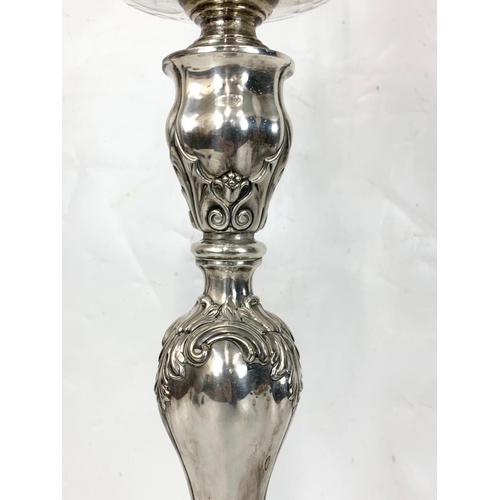 31 - A large Victorian silver plated oil lamp with an early 20th century shade. 83cm.