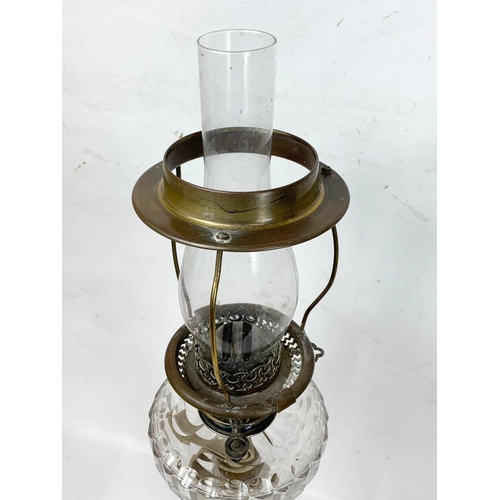 31 - A large Victorian silver plated oil lamp with an early 20th century shade. 83cm.