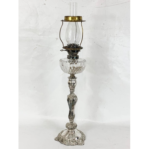 31 - A large Victorian silver plated oil lamp with an early 20th century shade. 83cm.