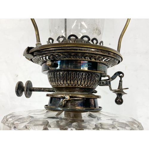 31 - A large Victorian silver plated oil lamp with an early 20th century shade. 83cm.