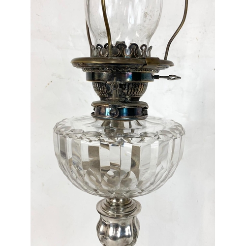 31 - A large Victorian silver plated oil lamp with an early 20th century shade. 83cm.