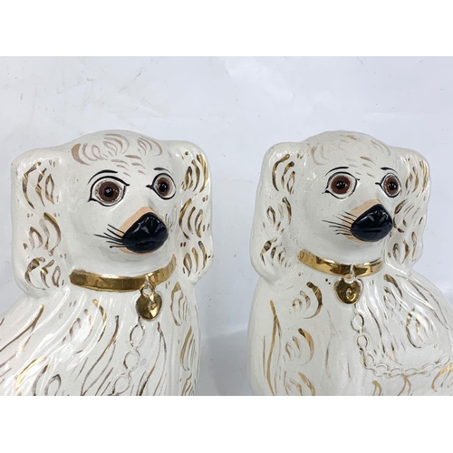 503 - A pair of large Victorian Staffordshire pottery dogs. 28 x 34cm