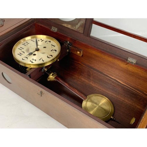 66 - An early 20th century oak cased wall clock. With key and pendulum. 78cm