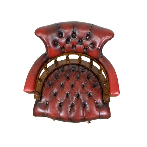 822 - A deep button leather ox-blood swivel captains desk chair.