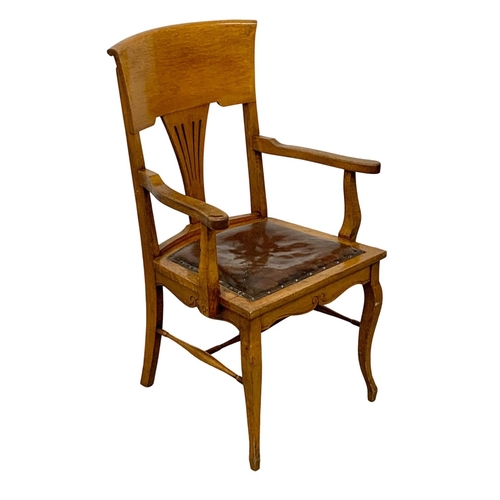 937 - An Edwardian oak high back armchair with original leather seat.