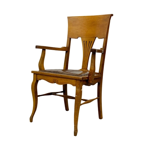 937 - An Edwardian oak high back armchair with original leather seat.